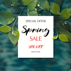 Creative layout made of green leaves with paper card mockup. Flat lay. Spring banner for online shopping, advertising actions, magazines and websites.