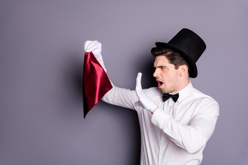 Profile side photo of funky wizard conjurer hold red napkin say spells want show focus wear white stylish shirt bow tie hat isolated over grey color background