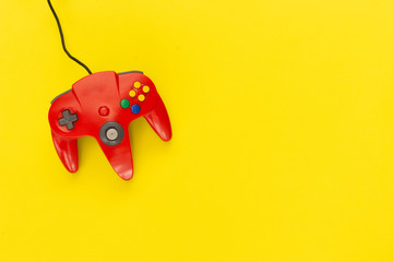 Red console gamepad of video game on yellow background. concept of fun and strategy.