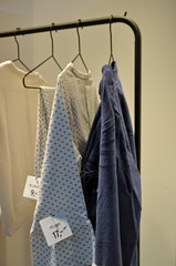 KLeidung auf Dr5ahtkleiderbügeln auf Kleiderstange in lockerer Reihe