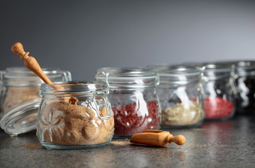 Various spices and herbs in glass jars.