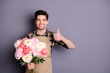 Photo of cheerful handsome man wearing checkered shirt showing thumb up leaving feedback about flower shop isolated grey color background