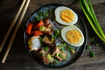 Asian broth with mushrooms and egg on a wooden background