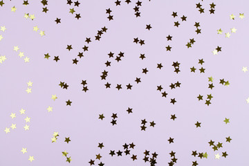 Holiday background with gold star confetti.