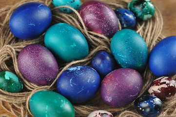 Easter eggs occupy the entire frame. Eggs are green, blue and purple. Macro shot.