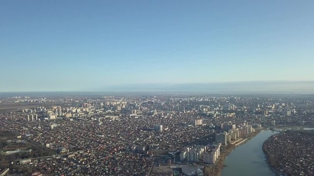 aerial view - the center of Krasnodar near the Kuban River on a sunny day on a snowless winter - bird's-eye view of multi-storey buildings, Minskaya Street, Turgenevsky Bridge