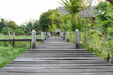 Old wooden bridge on green grass lawn.