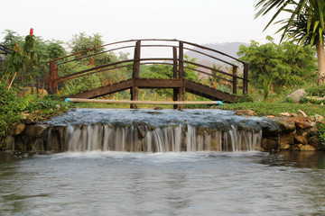 A wooden bridge crossing a small stream.