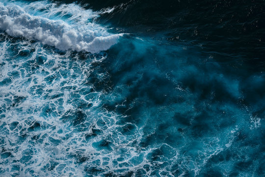 Aerial view to seething waves with foam. Waves of the sea meet each other during high tide and low tide. Dramatic colors photo. Image with place for text. © Dmitry Yakovtsev