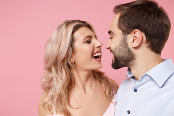 Close up of laughing young couple two guy girl in party outfit posing isolated on pastel pink wall background. Valentine's Day Women's Day birthday holiday concept. Doing selfie shot on mobile phone.