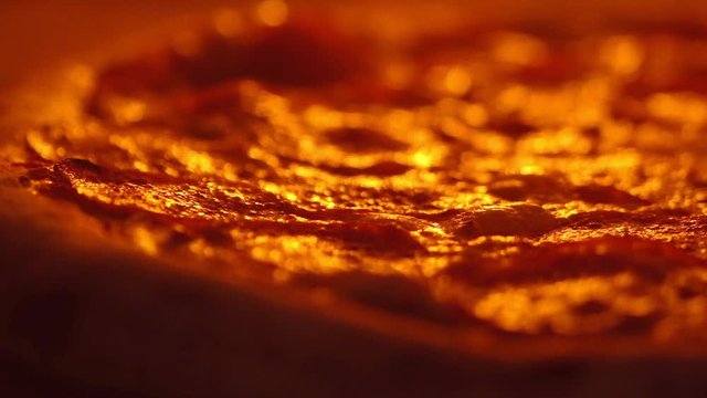 Pizza in the oven, bubbling cheese and a Golden crust. Close-up, cook the pizza rotates for even cooking