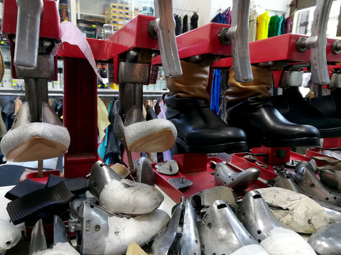 different shoes put on a special device for changing the size, a small Shoe repair shop