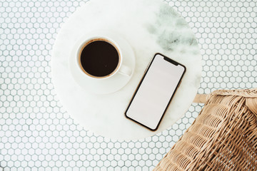 Blank screen mobile phone with empty copy space mockup on marble coffee table and mosaic tile. Flat lay, top view template for social media, website, blog, magazine.