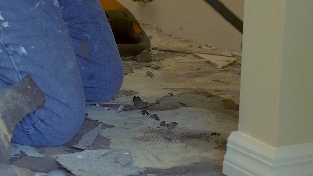 349 Construction worker breaking apart tile in a house