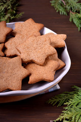 Gingerbread star cookies on a ceramic plate on the wooden table 