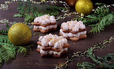 Honey star cakes with cream topped with golden sugar on the wooden table. Festive dessert