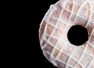 Glazed donut with sprinkles on a black background