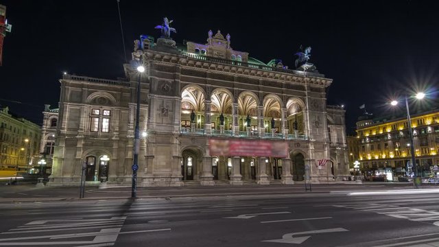 Beautiful view of Wiener Staatsoper (Vienna State Opera) night timelapse hyperlapse in Vienna, Austria. Illuminated historic buildings and traffic on streets