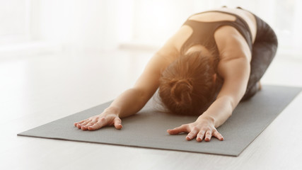 Fototapeta na wymiar Woman practicing yoga, stretching in Child exercise