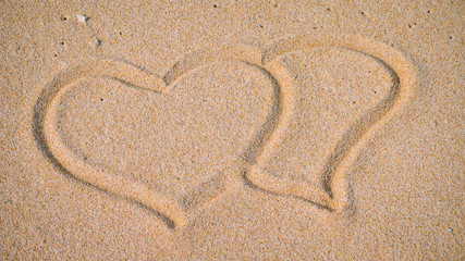 Fototapeta na wymiar Two Hearts in the Sand on the Beach