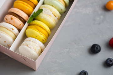 Colorfull different macaroons in the box on the grey background 