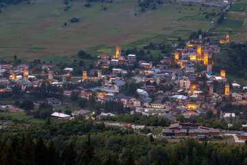 Evening view on Mestia with its illuminated Svan Towers. Svaneti, Georgia.