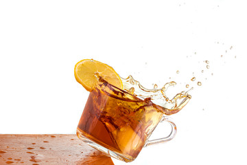 falling mug with tea or coffee on the corner of the table, splash and spills on a white background