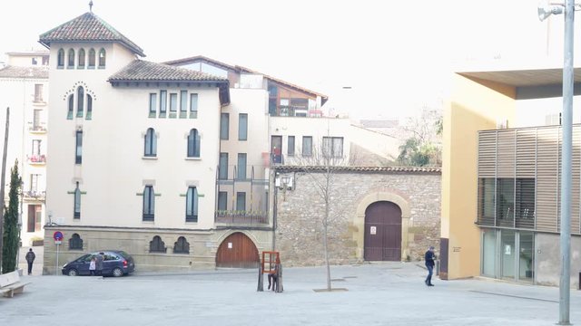 View of the west side of the Bisbe Oliva square, where some people walk. Vic, Catalonia, Spain