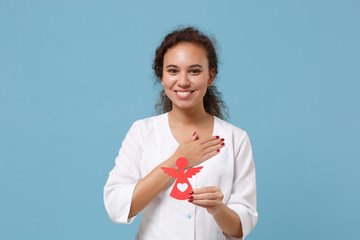 African american doctor woman isolated on blue background. Female doctor in white medical gown hold...