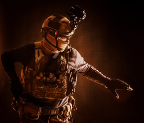 Special operations fighter in helmet with night-vision, thermal imaging device, load carrier...