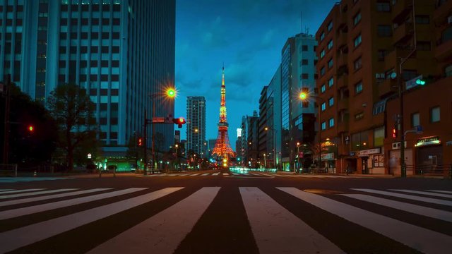 Time-lapse illumination view of business area street with view of Tokyo Tower in sunset night time. Night time Tokyo famous tourist attraction.Tokyo Olympic 2020 4K UHD video of Tokyo city in japan