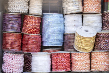 Fototapeta na wymiar Spools of beads. Different colors and varieties. Decorations are used in celebrations. Photo was taken outside in front of the store.