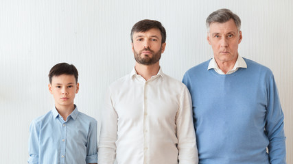 Boy, Father And Grandfather Standing Against White Wall Indoor, Panorama