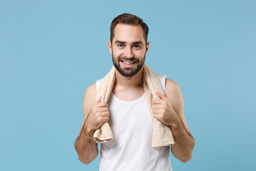 Close up bearded young man 20s years old in white shirt hold towel on shoulders isolated on blue pastel background studio portrait. Skin care healthcare cosmetic procedures concept. Mock up copy space