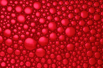 Abstract red background with soap bubbles in the water. Close-up. Macro.