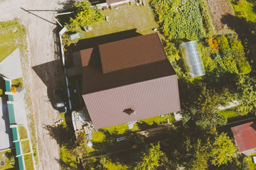Brown metal tile on the roof of the house. Corrugated metal roof