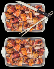 Fresh Spit Roasted Pork Meat Slices Offered in Ceramic Casserole Pan With and Without Carving Knife and Serving Fork Isolated on Black Background