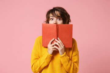 Young brunette woman girl in yellow sweater posing isolated on pink wall background studio...