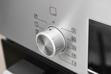 Button on a modern stove. Cooker handles. closeup of a control panel