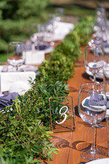 Preparing for an open-air party. Decorated with fresh flowers served tables. Table number. Decoration Details