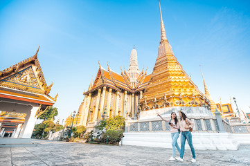  women friends enjoy sightseeing while travel in temple of the emerald buddha in Thailand - obrazy, fototapety, plakaty
