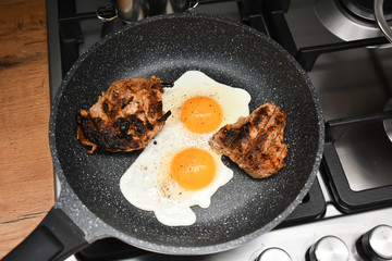 Scrambled eggs and meat in a frying pan