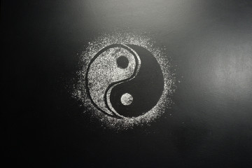 Drawing flour on a black board. Yin Yang