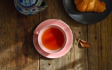 Pink Cup with fragrant tea on a wooden background. Tea mood. Tea composition.