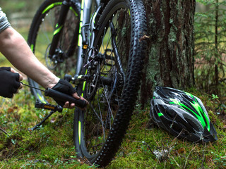 cyclist repairs a bike in the forest. 