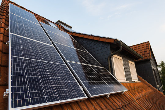 Solarpanels auf Hausdach mit Gaube im Hintergrund