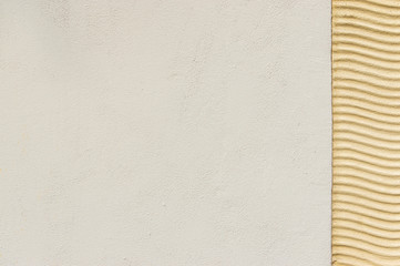 Wellenlinien als Ornament aus Putz auf Außenfassade in Farbe beige auch als Hintergrund nutzbar, mittlere, lange und kurze Brennweite, mit angrenzenden Putz und viel Textfreiraum