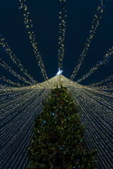 Christmas tree with the golden threads decorated for new year holiday on the dark background
