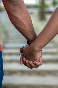 pareja agarrada de manos en un camino de piedra