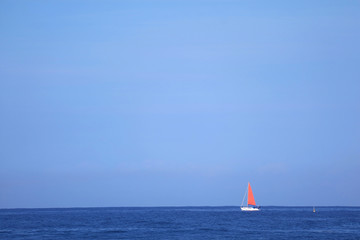 Red Sail Yacht in Sailing on the Deep Blue Ocean 